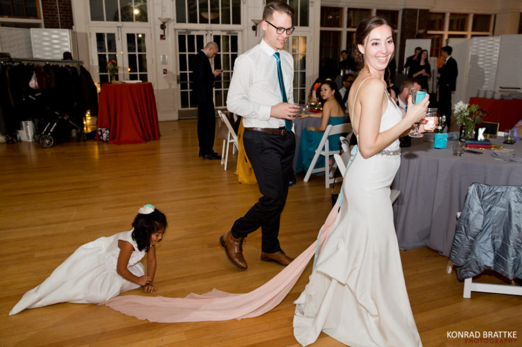 A bride and a little girl dancing at a wedding reception.