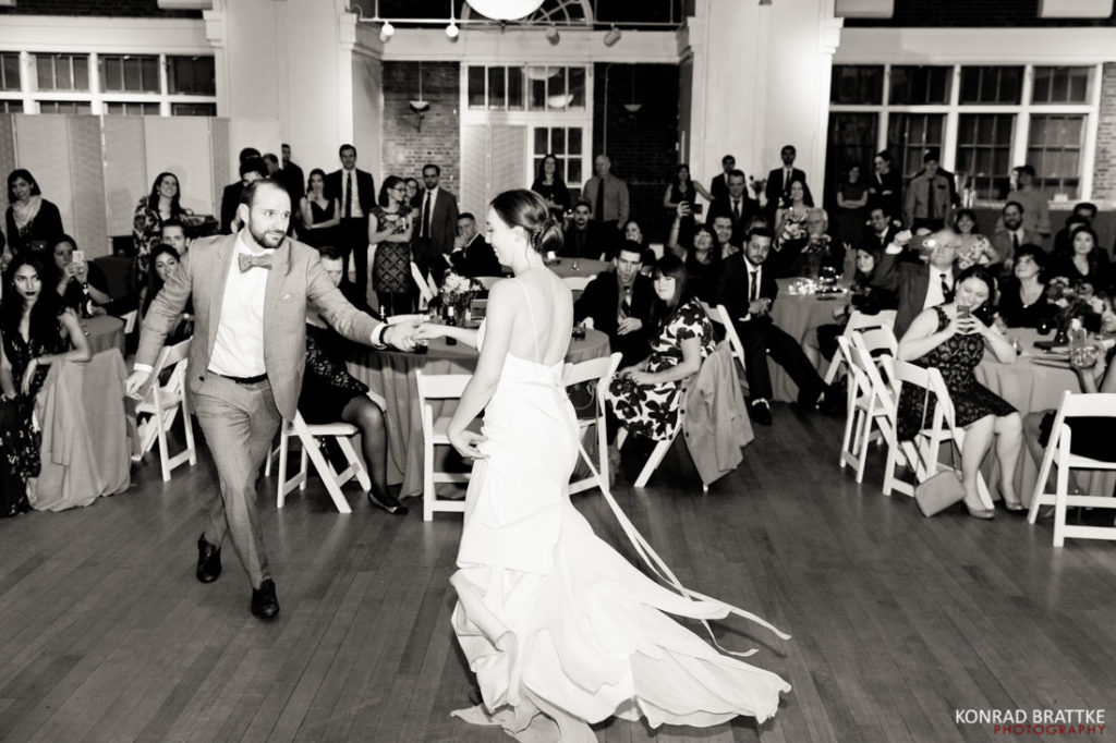A bride and groom dance in front of a large crowd at the Picnic House in Prospect Park.