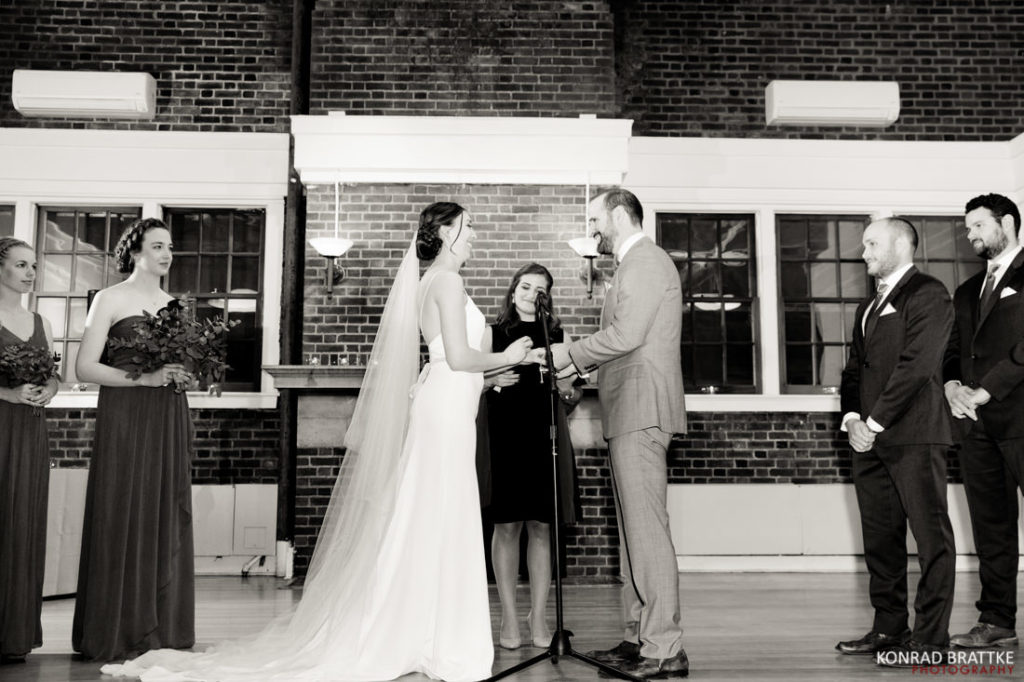 A bride and groom exchange vows during their Prospect Park wedding ceremony, surrounded by their wedding party.