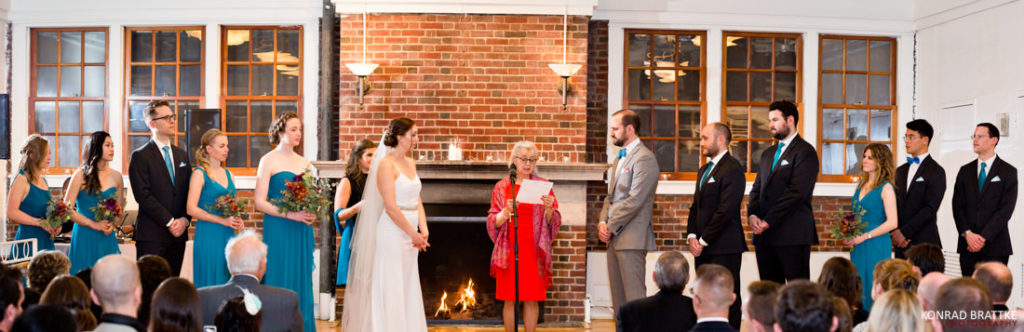 A group of people standing in front of a fireplace at a Prospect Park Wedding.