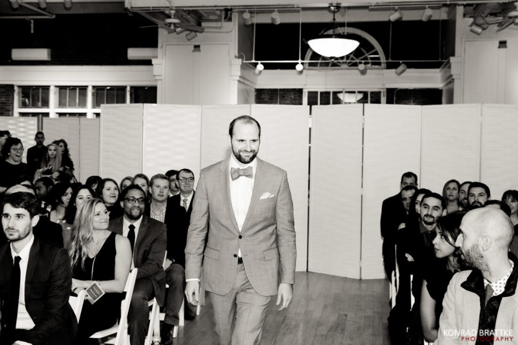 A man in a suit strutting down the aisle at a Prospect Park Wedding.
