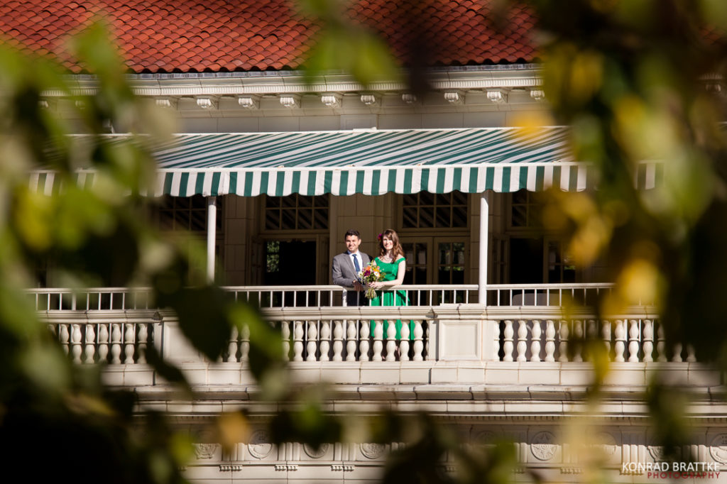 A couple standing on the balcony of a Boathouse in Prospect Park.