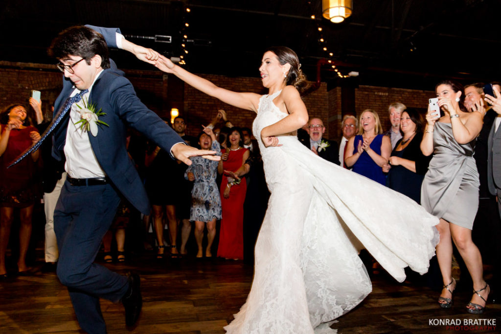 A bride and guest dancing at the 26 Bridge wedding reception.