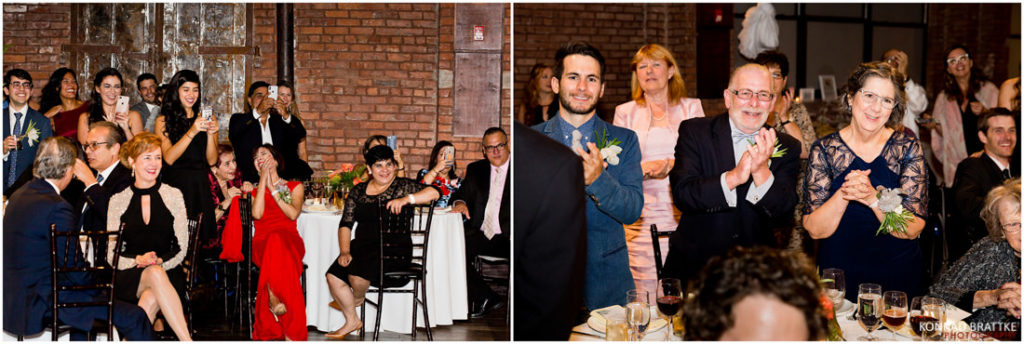 A group of people clapping at a 26 Bridge wedding reception.