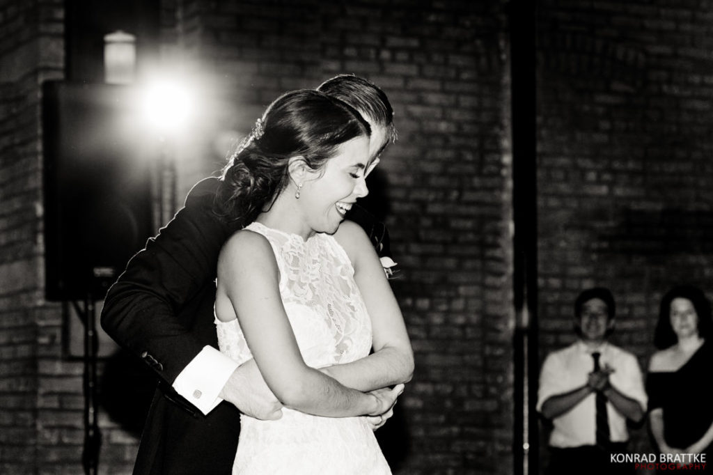 A bride and groom hugging during their first dance at 26 Bridge.
