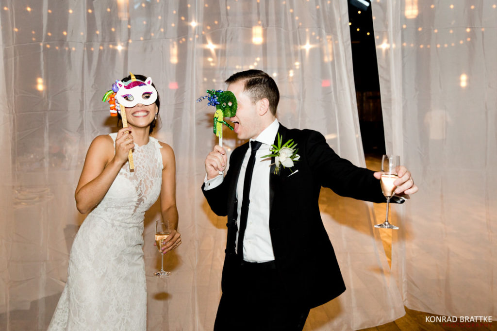 A bride and groom wearing masks at their 26 Bridge wedding reception.