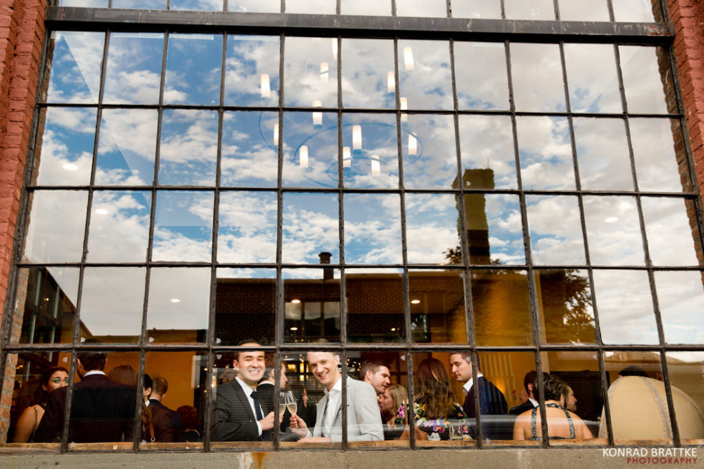 A group of people standing in front of a 26 Bridge window.