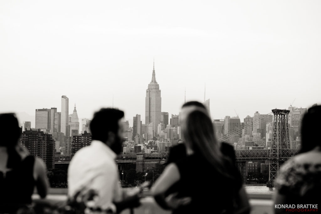 A black and white photo of people looking at the Empire State Building during a Brooklyn Grange Wedding.