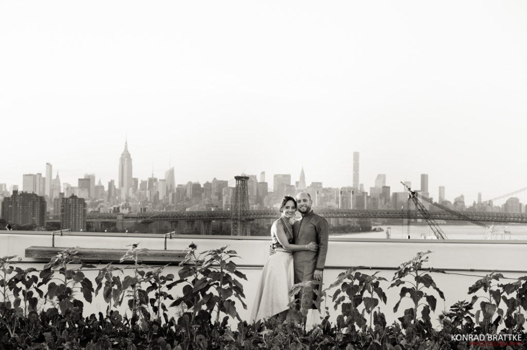 A Brooklyn Grange wedding with a bride and groom standing on a rooftop overlooking the skyline.