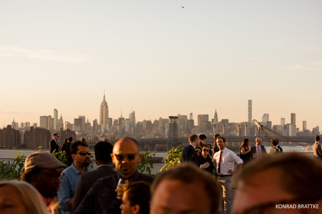 A group of people standing in front of a city skyline during a Brooklyn Grange Wedding.