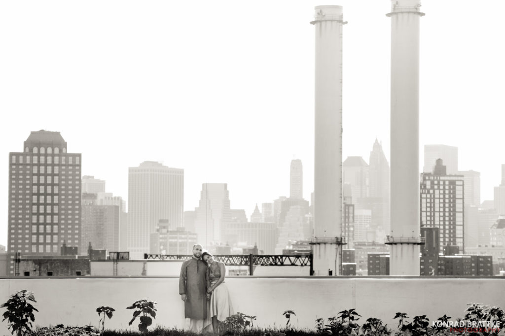 A black and white photo of a couple standing on a rooftop during their Brooklyn Grange Wedding.
