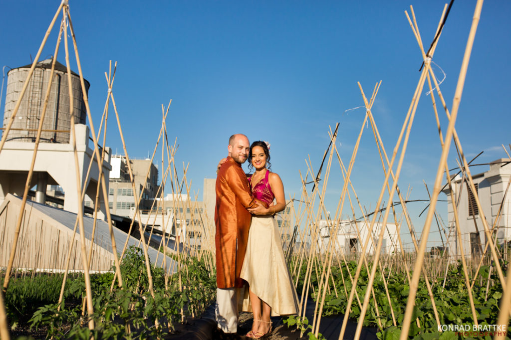 A wedding couple poses for a photo in the Brooklyn Grange garden.