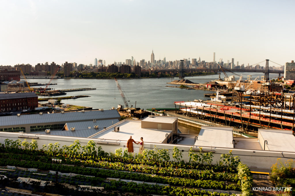 A bride and groom is standing on a Brooklyn rooftop.