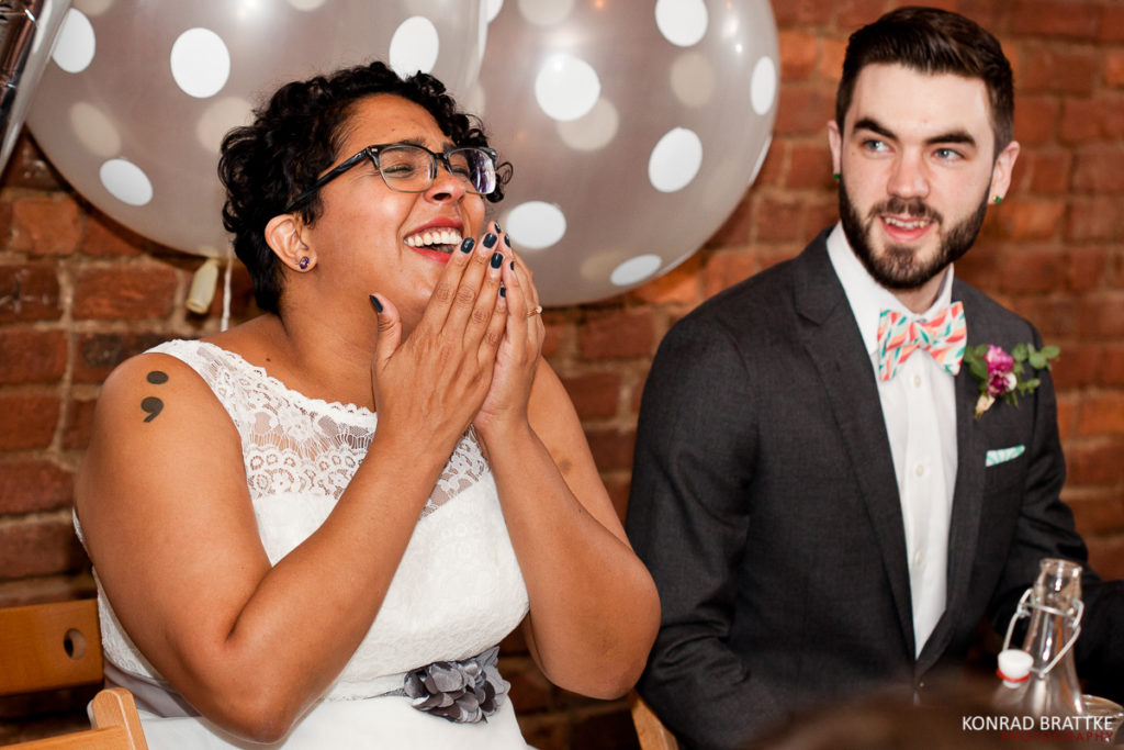 A Brooklyn bride and groom laughing at their wedding reception.