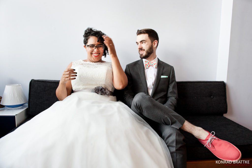 A Brooklyn bride and groom sitting on a couch.