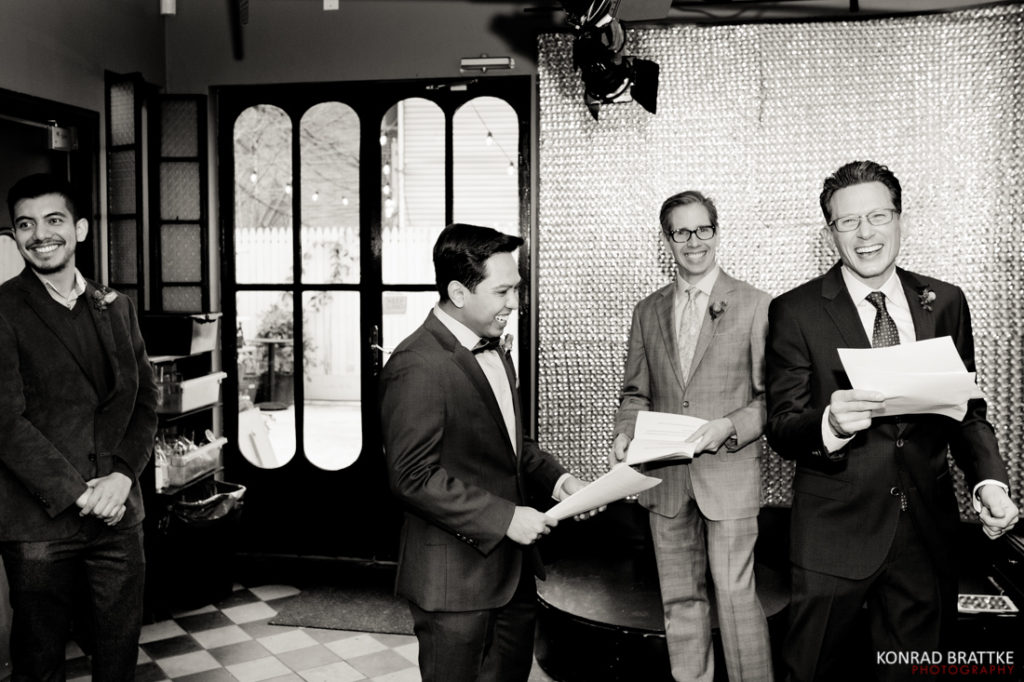Le Fanfare - A black and white photo of a group of men holding papers.