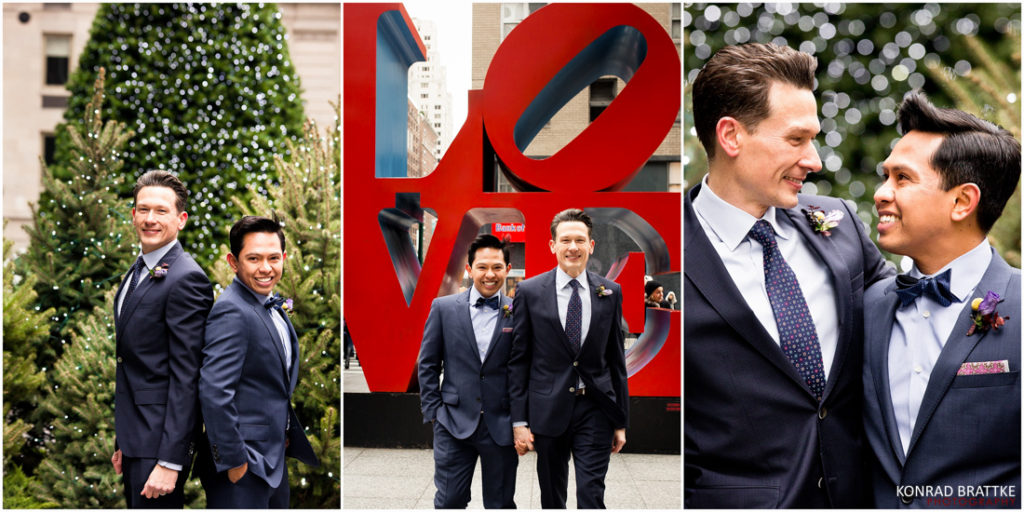 Two grooms posing in front of a love sign.