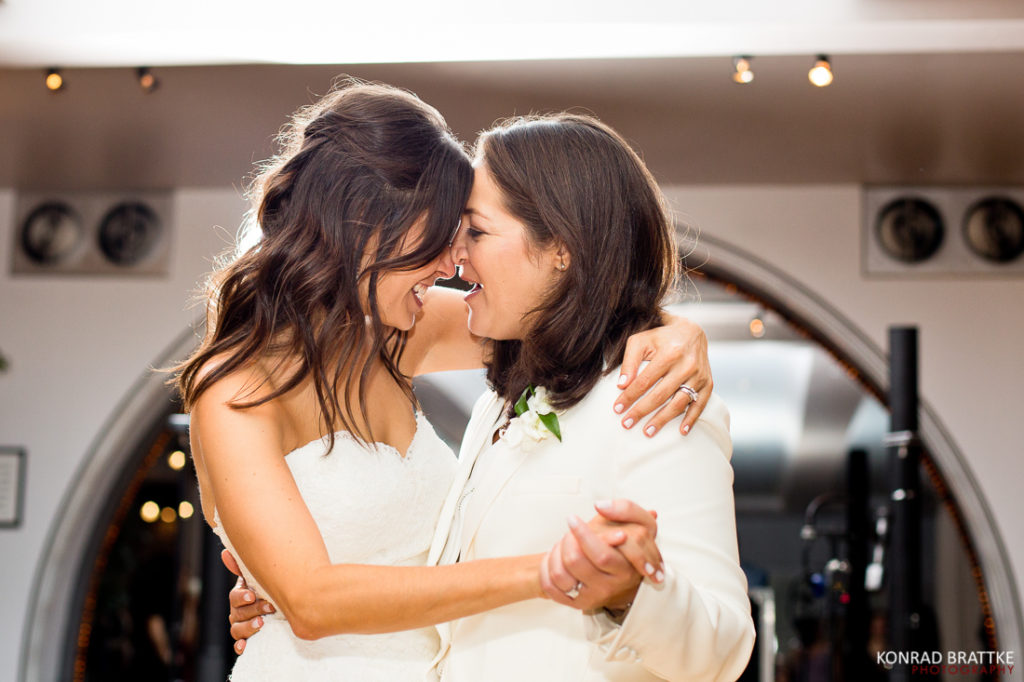 Two brides share a kiss during their Manhattan Penthouse wedding first dance.