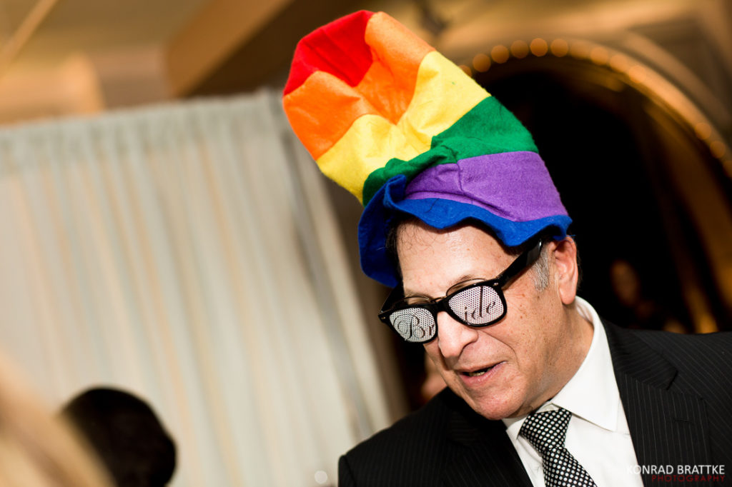 A man in a suit wearing a rainbow hat at a Manhattan Penthouse wedding.