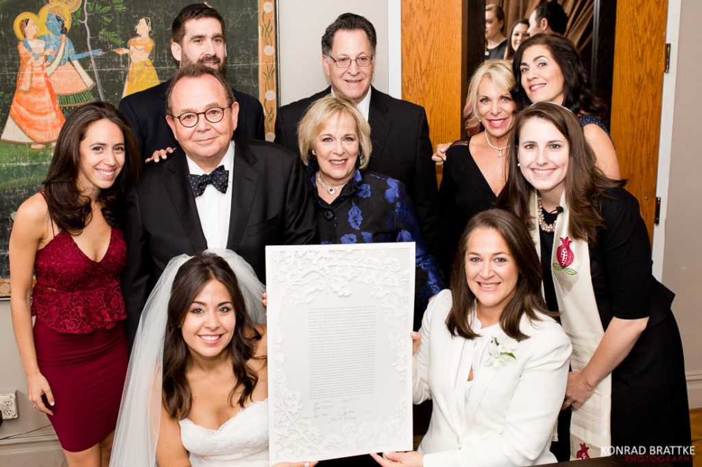 A Manhattan Penthouse wedding ceremony where a group of people is posing for a picture.