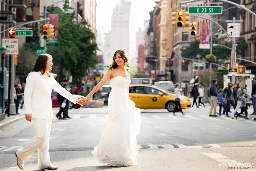 Two brides happily walking down a city street after their luxurious Manhattan Penthouse wedding.