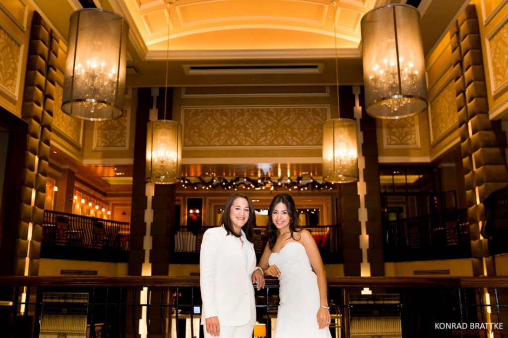 Two brides posing in the lobby of a Manhattan Penthouse wedding.