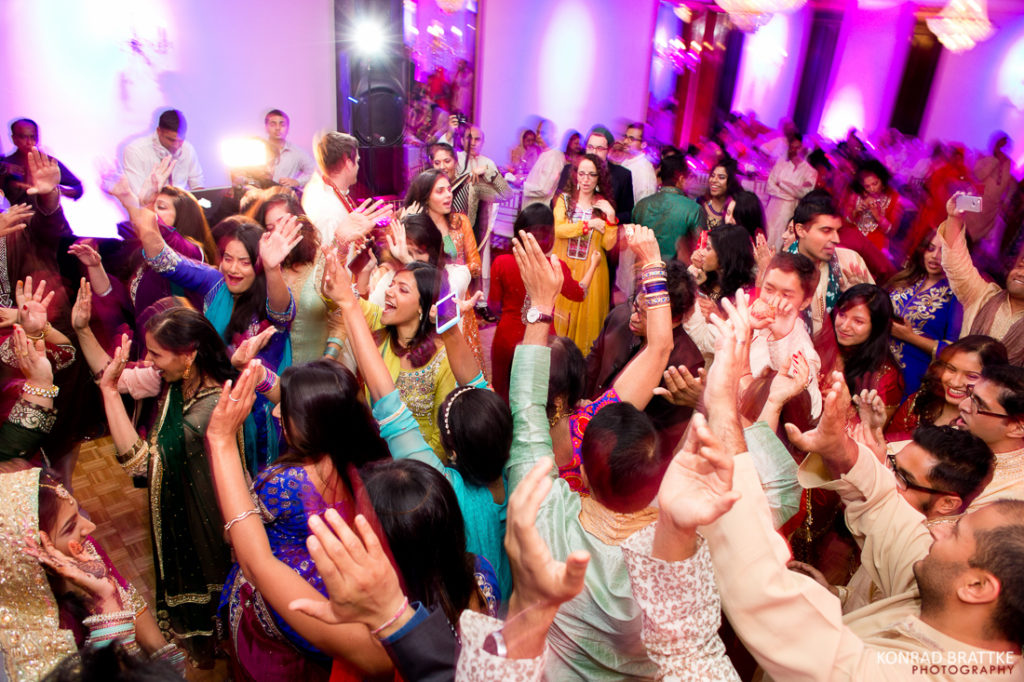 A lively group of people dancing at a vibrant mehndi, filled with the energetic festivities.