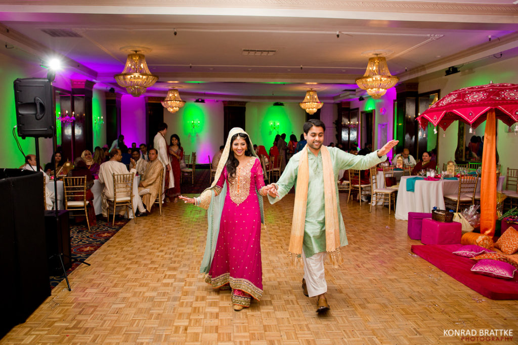 The mehndi-adorned bride and groom gracefully glide across the dance floor at Antuns, radiating joy and celebration during their vibrant Indian wedding.