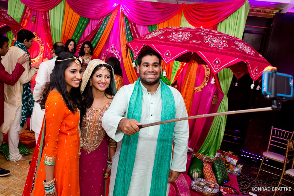 A group of people taking a selfie at an Indian wedding during the mehndi celebration at Antuns.