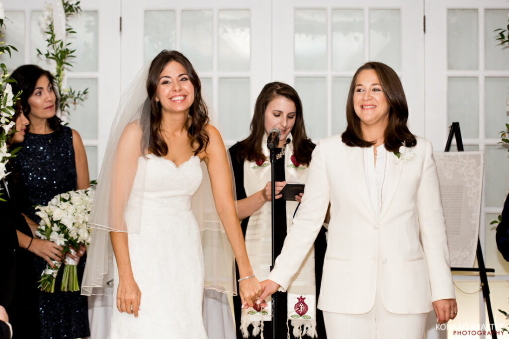Two brides gracefully walking down the aisle at their wedding ceremony.