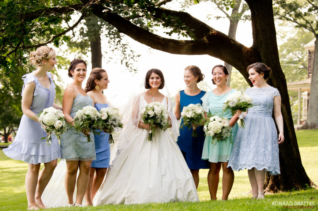 A group of bridesmaids standing in front of a tree.