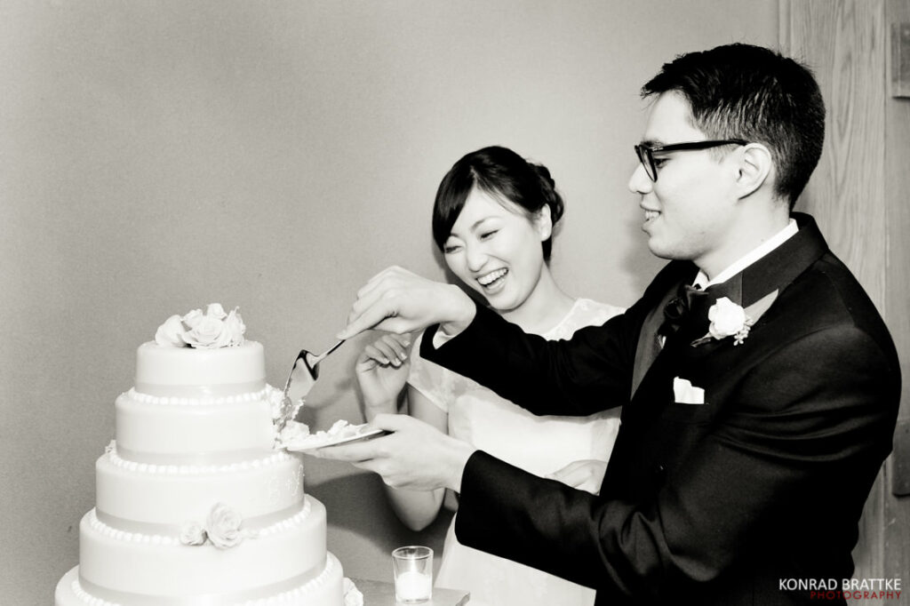 The bride and groom cutting into their exquisite wedding cake.