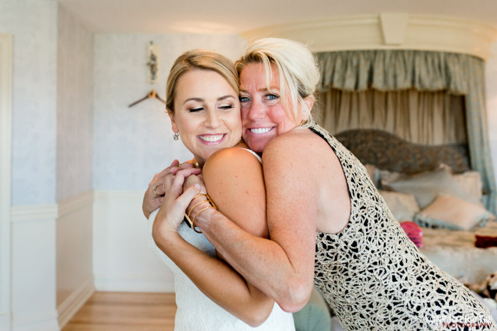 The Best of weddings captured in a heartwarming moment, as a bride shares an emotional hug with her mother in the bedroom.