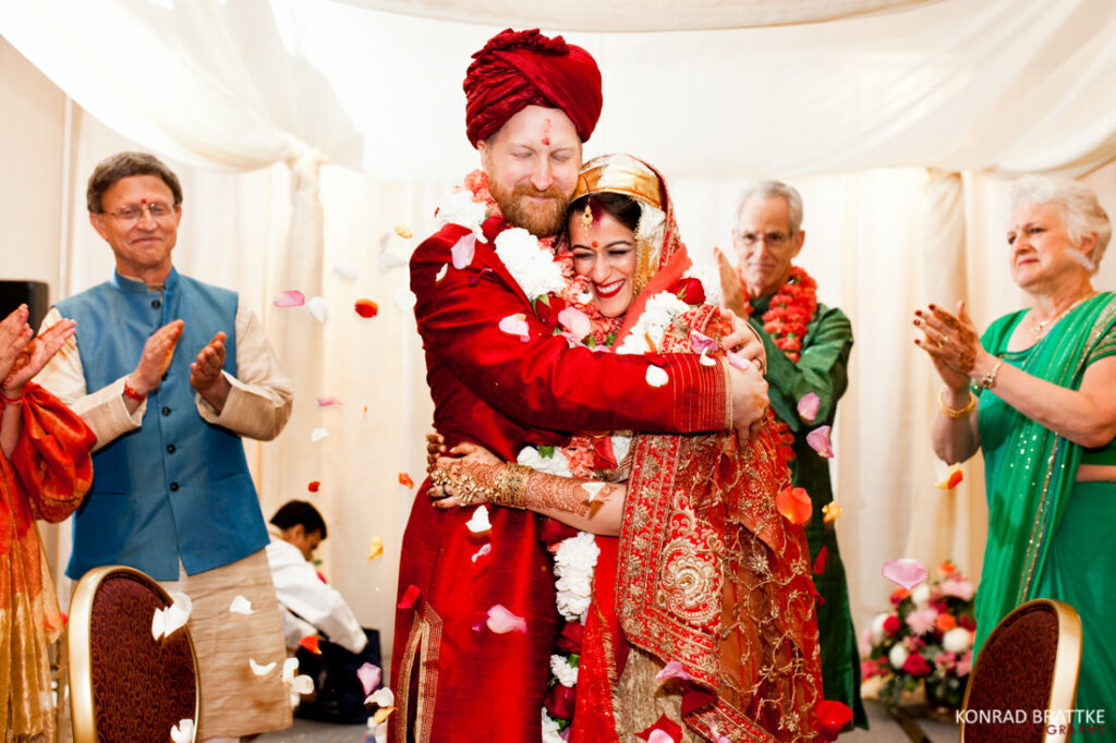 Konrad Brattke Photography's best of weddings captured in a heartwarming moment, as a bride and groom share an emotional hug in front of a crowd of people.