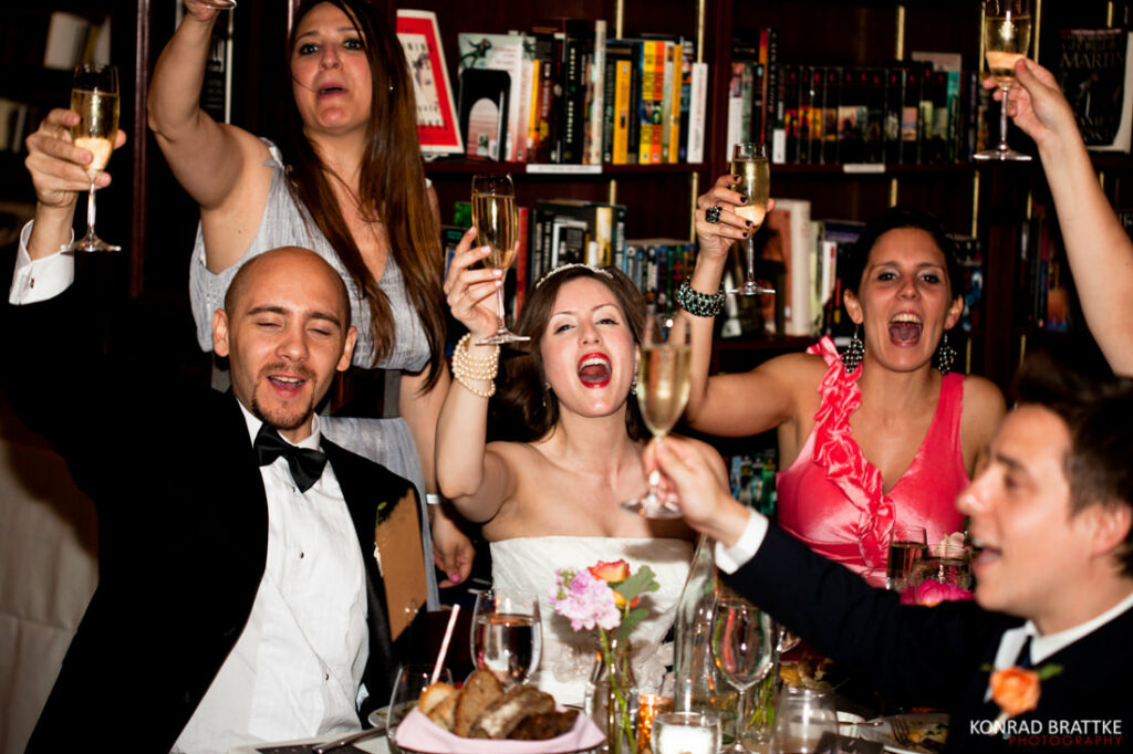 A group of people holding champagne glasses during a wedding reception.