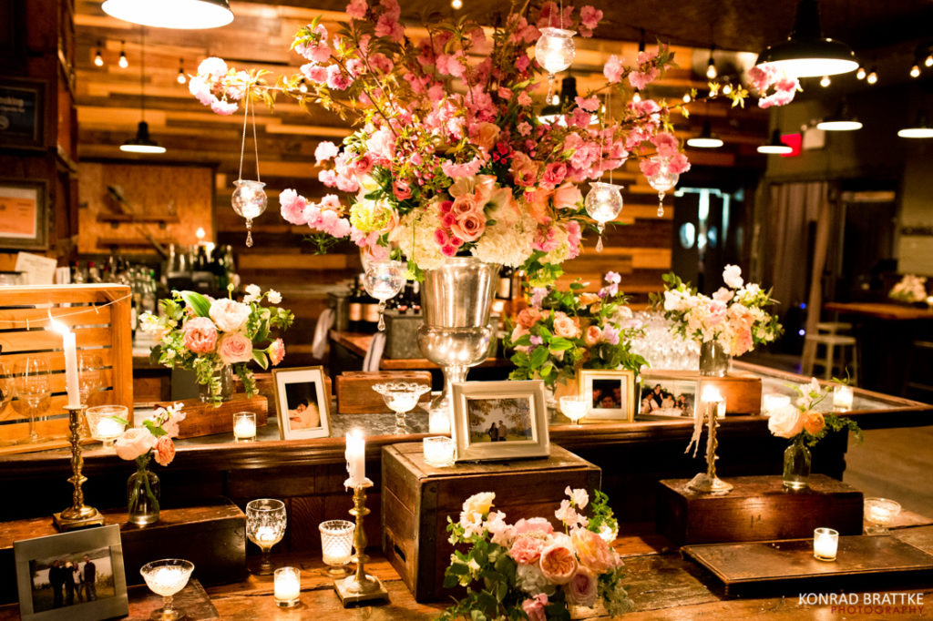 At the Brooklyn Winery, an elegantly set table awaits you, adorned with a delightful arrangement of flowers and candles.