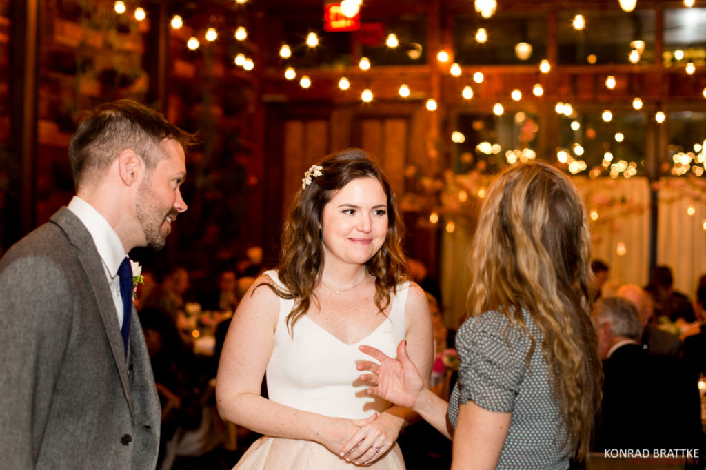 A bride and groom conversing with each other at their wedding reception held at the Brooklyn Winery.