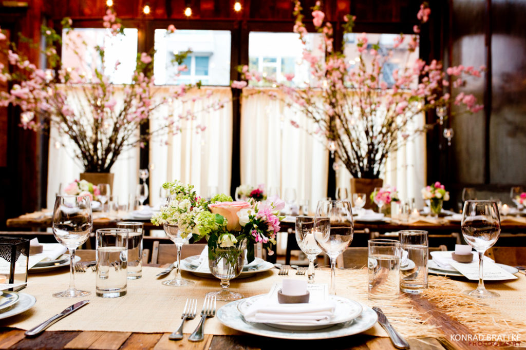 A wooden table with flowers in it, inspired by the rustic charm of Brooklyn Winery.