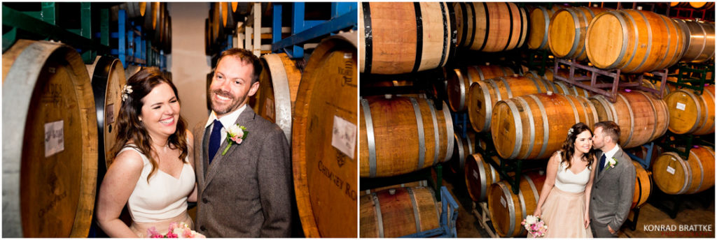 A bride and groom posing in front of wine barrels at Brooklyn Winery.