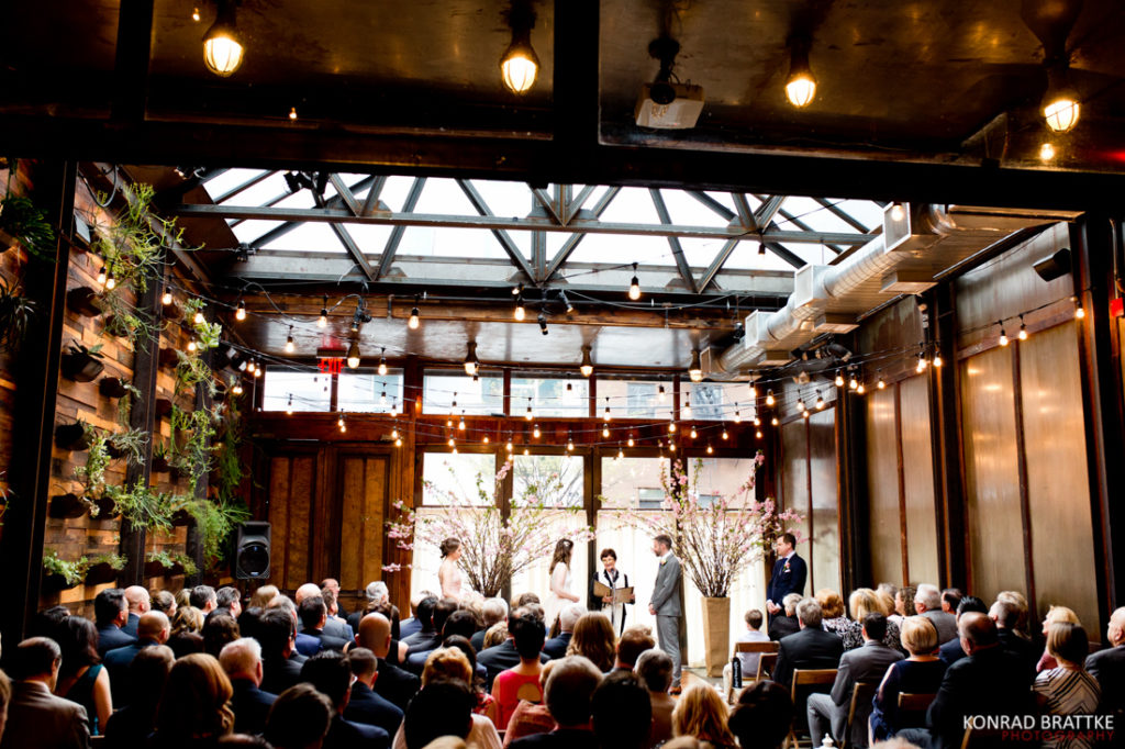 A wedding ceremony at Brooklyn Winery with a lot of people.