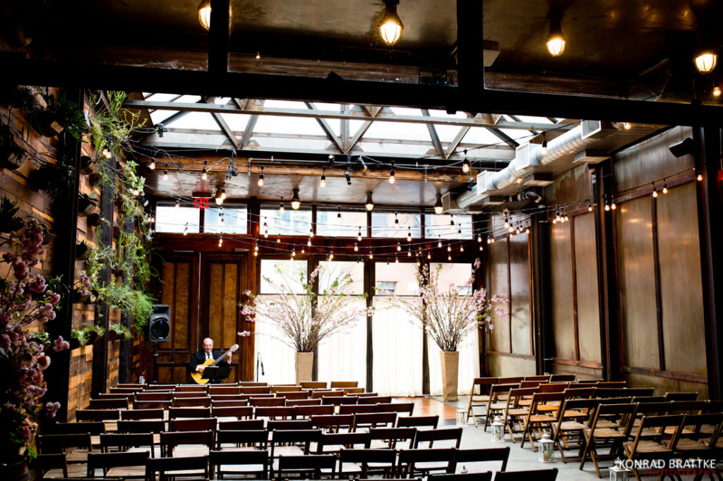 A wedding ceremony at the the Brooklyn Winery, set in a large room with rows of chairs.