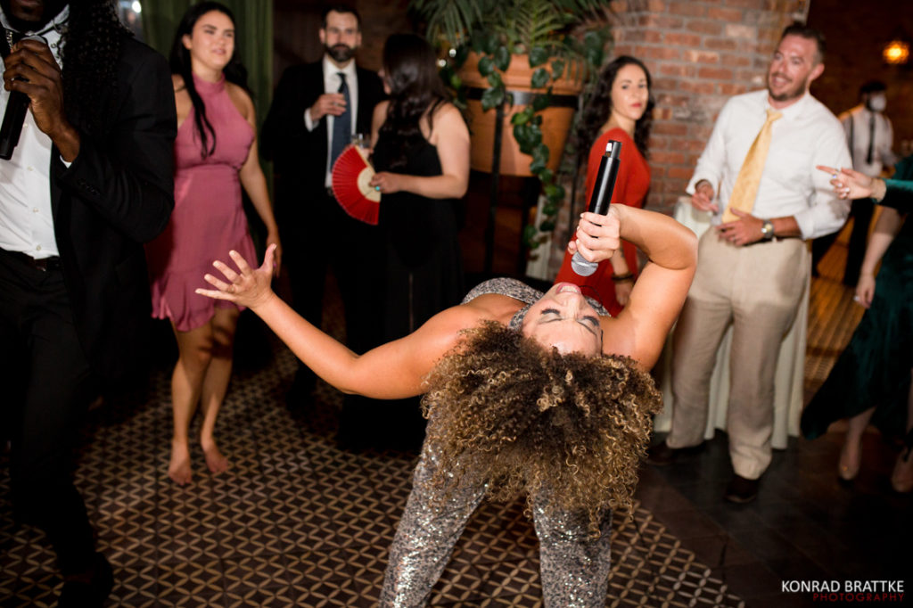 A woman dancing with a microphone at a wedding party at the Bowery Hotel.