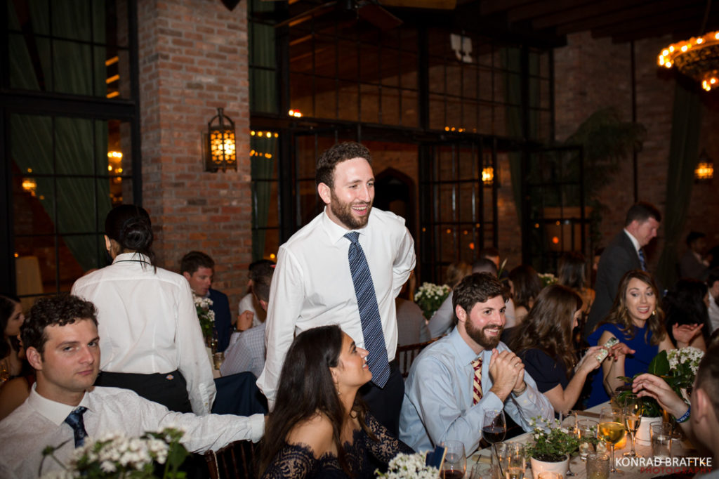 A man in a tie is standing at a wedding reception at the Bowery Hotel.