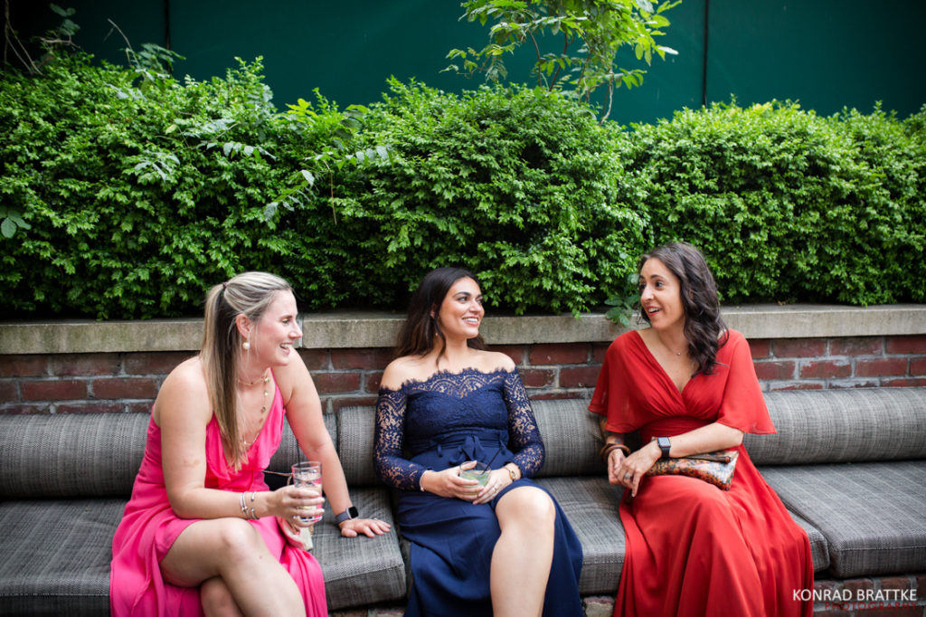Three bridesmaids sitting on a couch at a Bowery Hotel wedding.