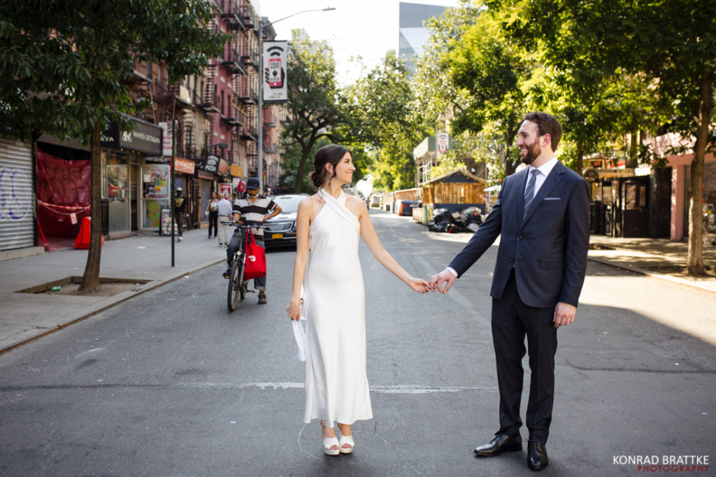 A bride and groom holding hands outside Bowery Hotel, a charming city street wedding venue.