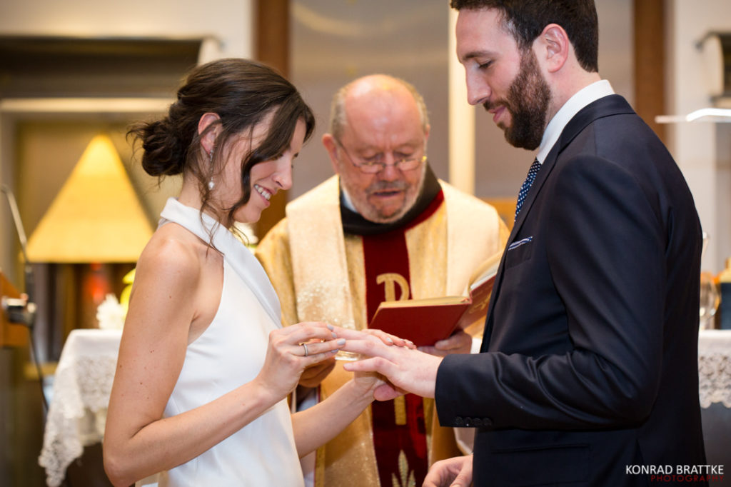 A bride and groom exchanging rings in a church during their wedding.
