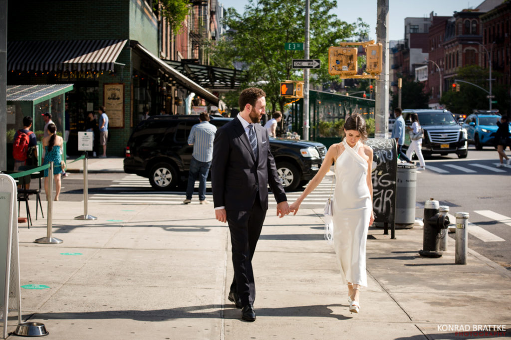 A bride and groom strolling down the city street after their Bowery Hotel wedding.