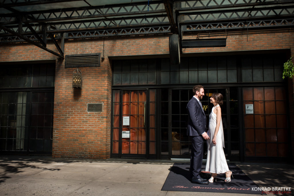 A bride and groom standing in front of the elegant Bowery Hotel for their special wedding day.