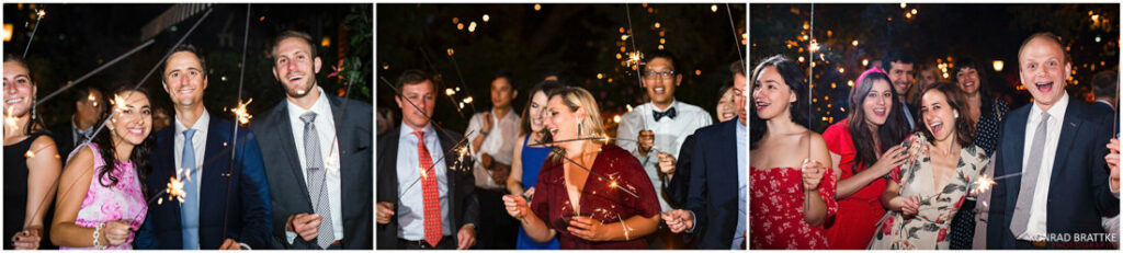 A group of people holding sparklers at a wedding at the River Cafe.