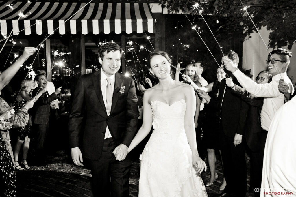A bride and groom exciting the river cafe with sparklers.